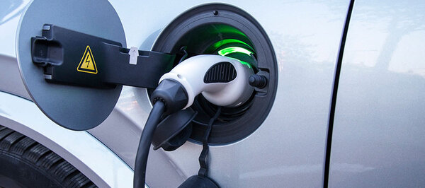 Ein Auto wird über ein Stecker der Ladestation aufgeladen