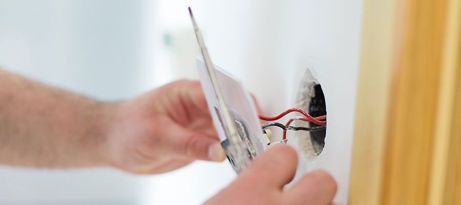 Ein Mitarbeiter installiert eine Steckdose