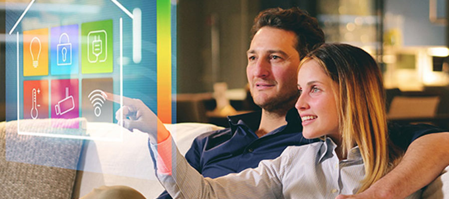 Ein Mann und eine Frau sitzen auf einem Sofa und nutzen ihr Smart Home Anwendung